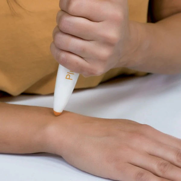 Personne utilisant le stylo Paingone Plus sur le poignet